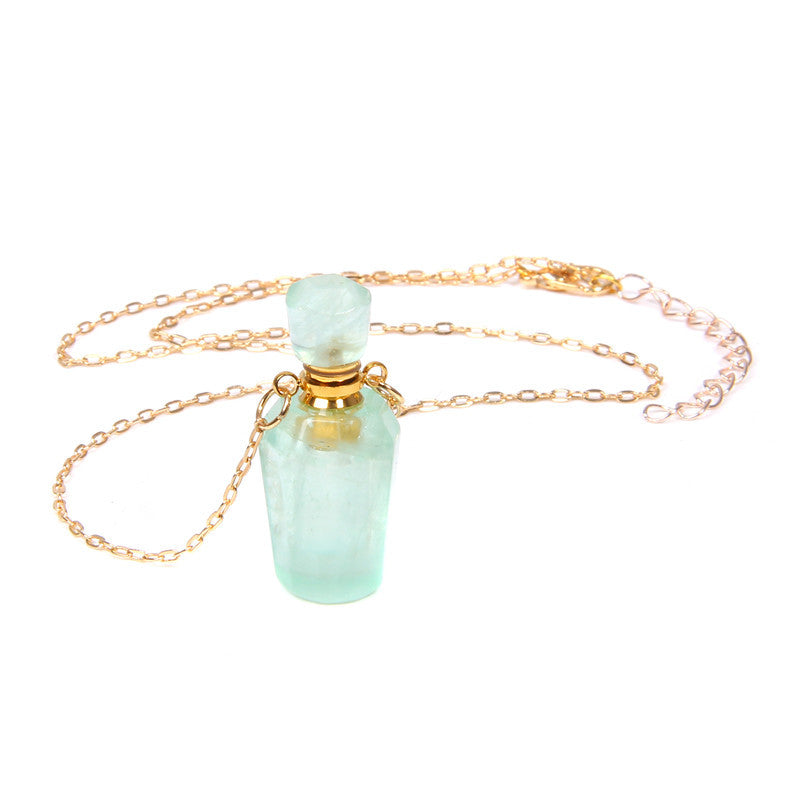 Necklace with a green pendant and gold chain on a white background