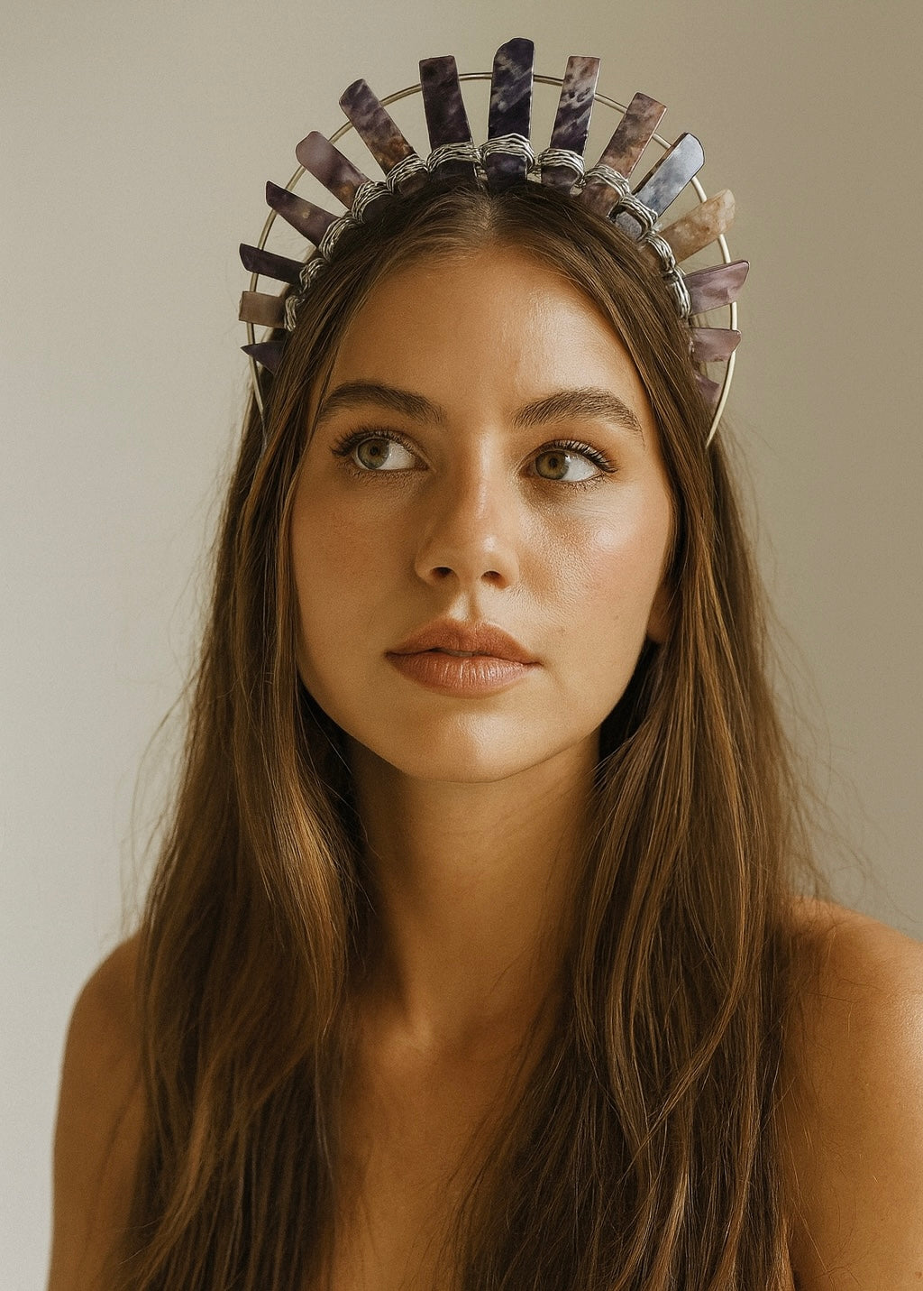 Woman wearing a decorative headpiece with a neutral background