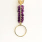 Purple beaded keychain with gold butterfly on a white background