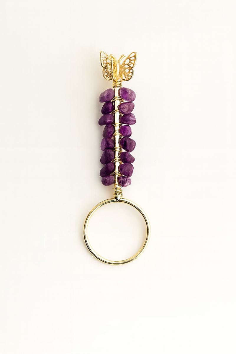 Purple beaded keychain with gold butterfly on a white background