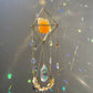 Decorative crystal hanging with colorful beads against a dark background