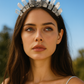 Woman wearing a crystal crown against a clear blue sky
