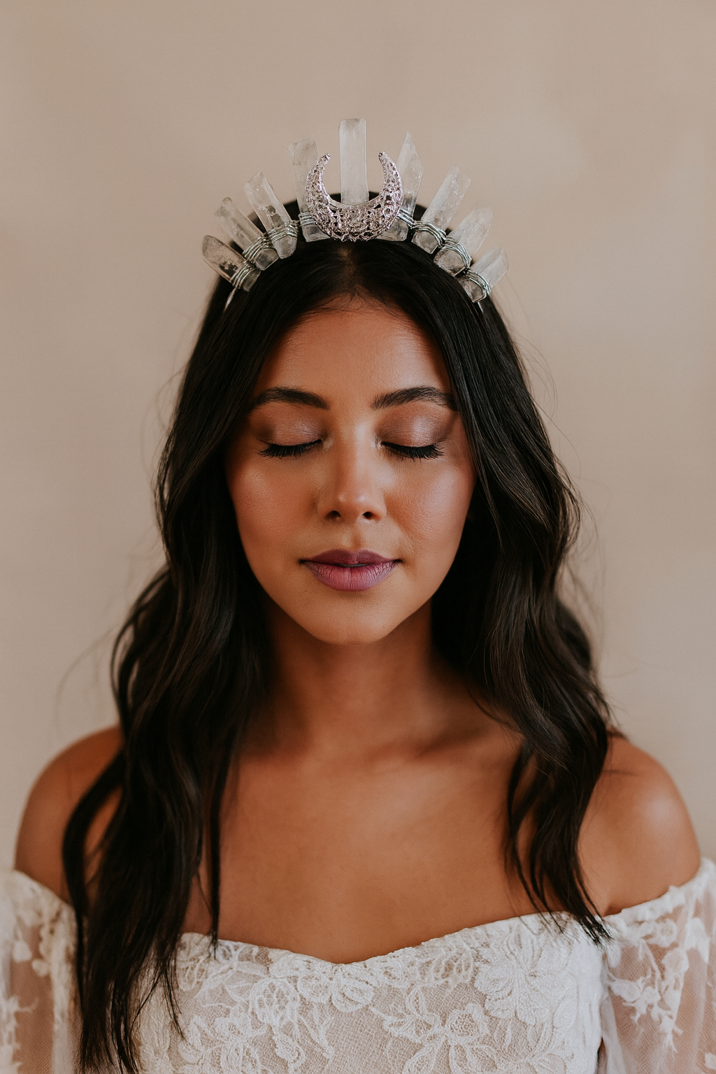 Woman wearing a silver tiara against a plain background