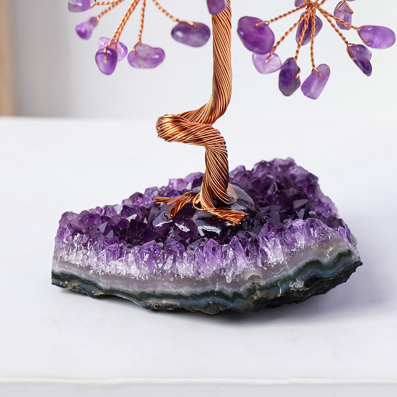 Amethyst crystal tree on a purple crystal base with a white background