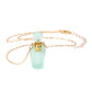 Necklace with a green pendant and gold chain on a white background