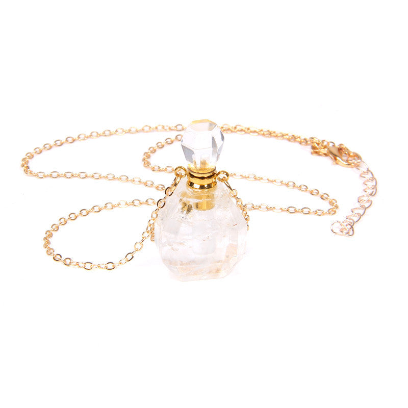 Necklace with a clear glass pendant and gold chain on a white background