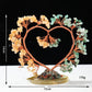 Decorative heart-shaped sculpture with floral elements on a black background