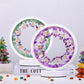 Two circular coasters with floral designs on a white surface with decorative items.