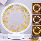 Round decorative lamp with floral design and glowing center on a white surface.