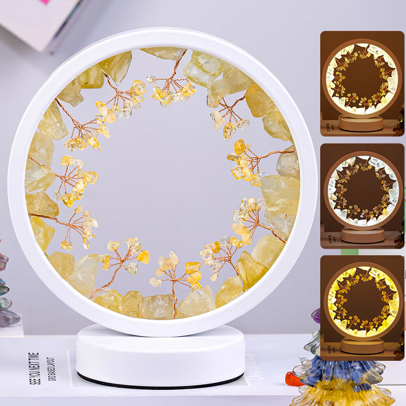 Round decorative lamp with floral design and glowing center on a white surface.
