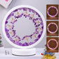 Round decorative item with purple stones and branches on a white base, surrounded by additional items.