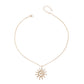 Gold necklace with a sun-shaped pendant on a white background