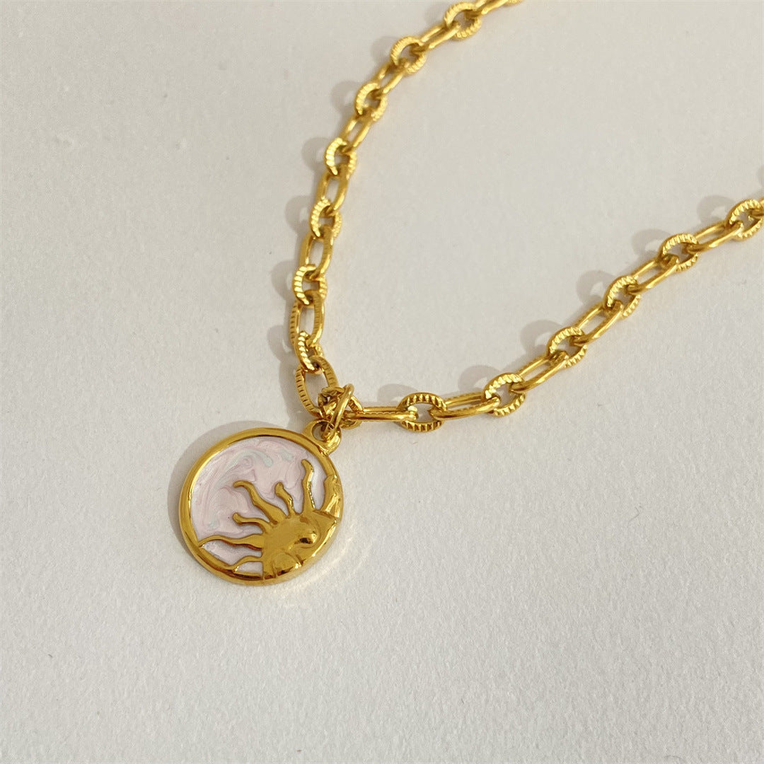 Gold bracelet with a lobster charm on a light gray background