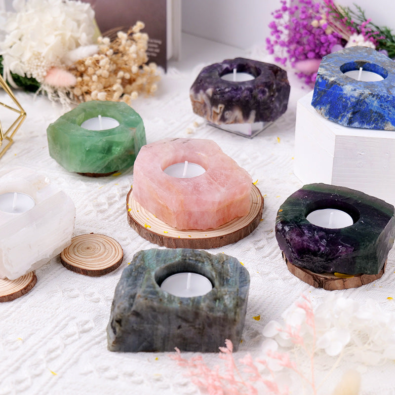 Set of stone candle holders on a white surface with decorative elements.