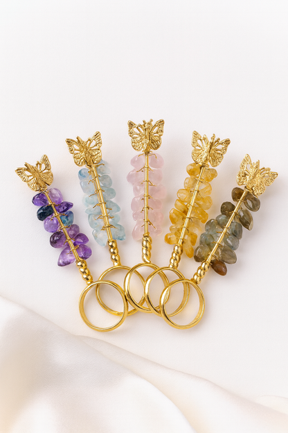 Set of decorative sticks with colorful beads and gold butterfly accents on a white background