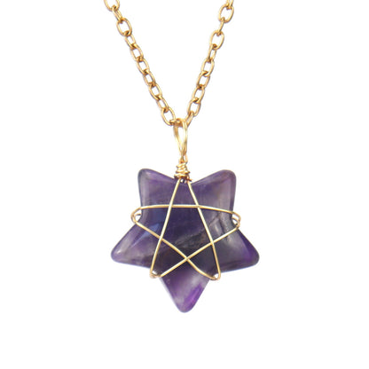 Purple star-shaped pendant with gold wire wrapping on a gold chain against a white background
