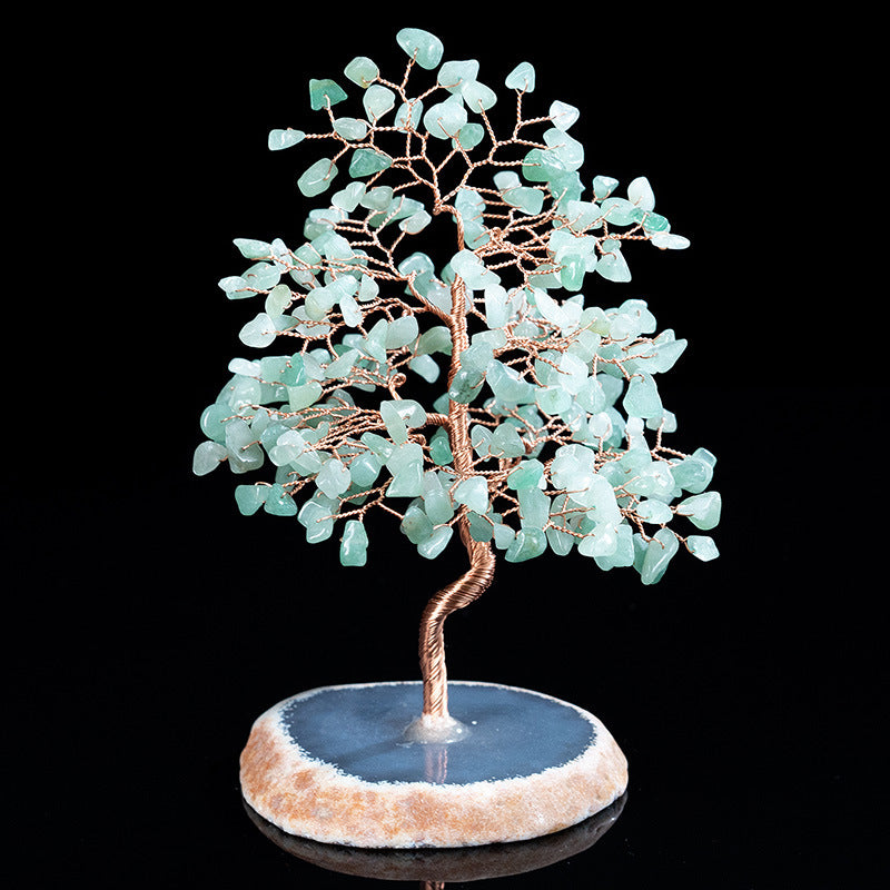 Decorative tree sculpture with turquoise stones on a dark background