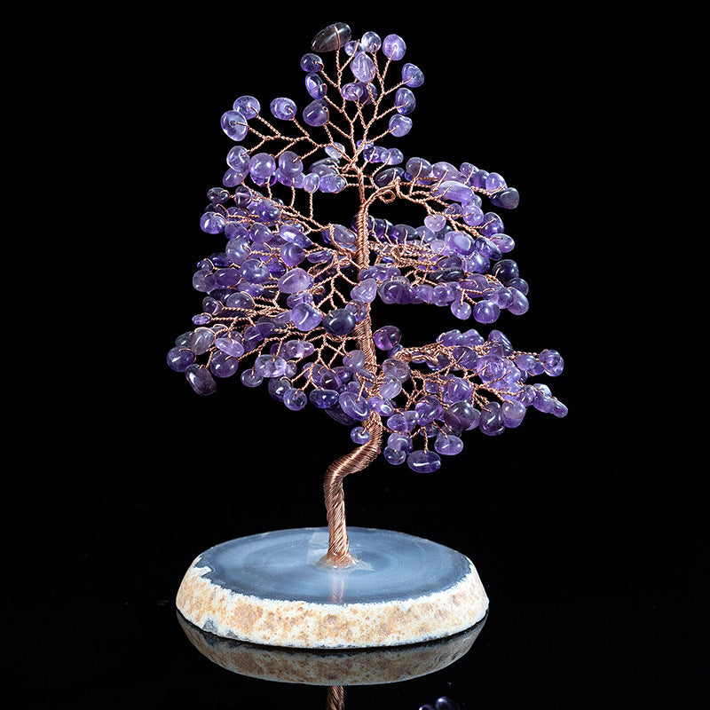 Decorative tree sculpture with purple stones on a black background