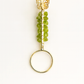 Decorative ring with green beads and a gold butterfly on a white background