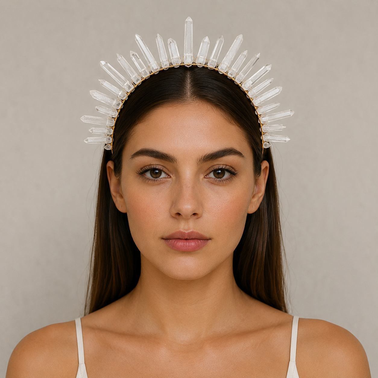 Woman wearing a crystal headband against a neutral background