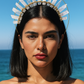 Woman wearing a decorative headpiece against a blue sky and ocean background