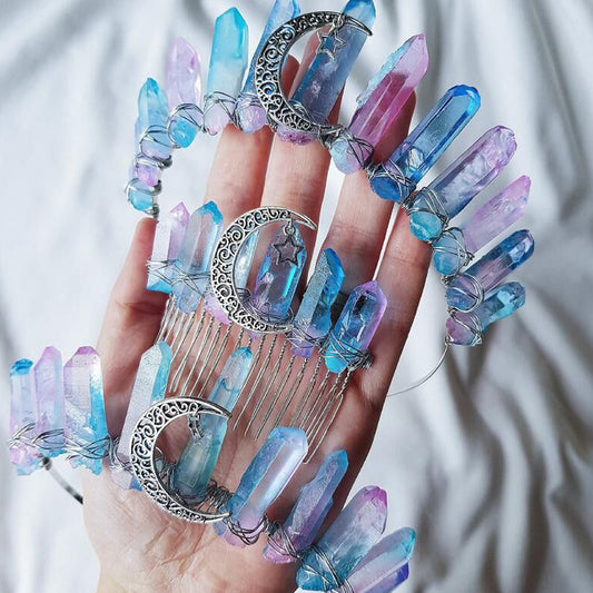 Hand with crystal nail art and a decorative hair comb against a white background