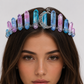 Woman wearing a colorful crystal tiara on a plain background