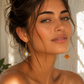 A close-up lifestyle shot of a woman with her hair in an updo, wearing gold celestial dangle earrings with blue and orange stones, set against a softly lit white wall.