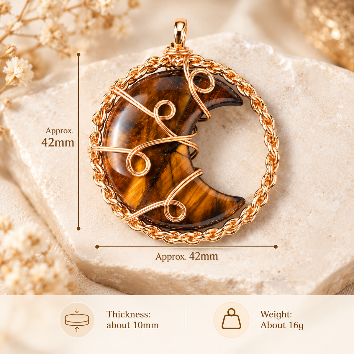 A gold-toned crescent moon pendant with a tiger's eye inlay, shown with dimension lines indicating an approximate height and width of 42mm, plus a bottom banner with thickness and weight details.