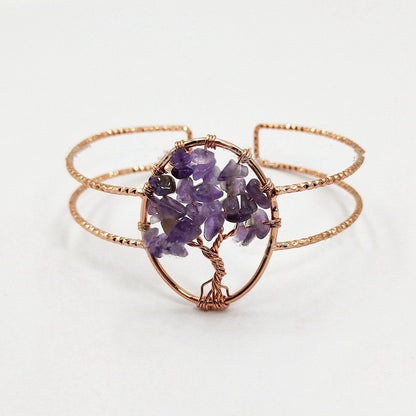 A rose gold wire-wrapped cuff bracelet featuring a central cluster of purple amethyst gemstones arranged in a tree-of-life pattern, shown on a clean white background.